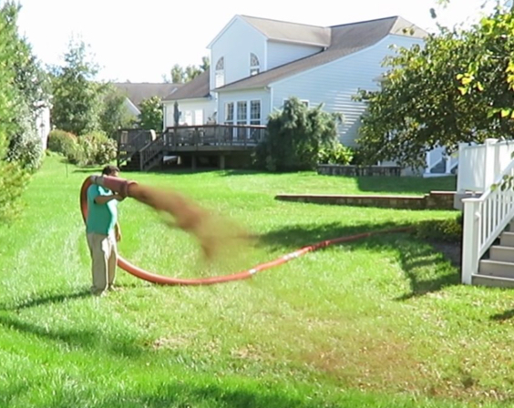 Shearon Environmentalist topdressing by using a blower to spread Cyclone Compost on the landscape at The Traditions at Longwood neighborhood